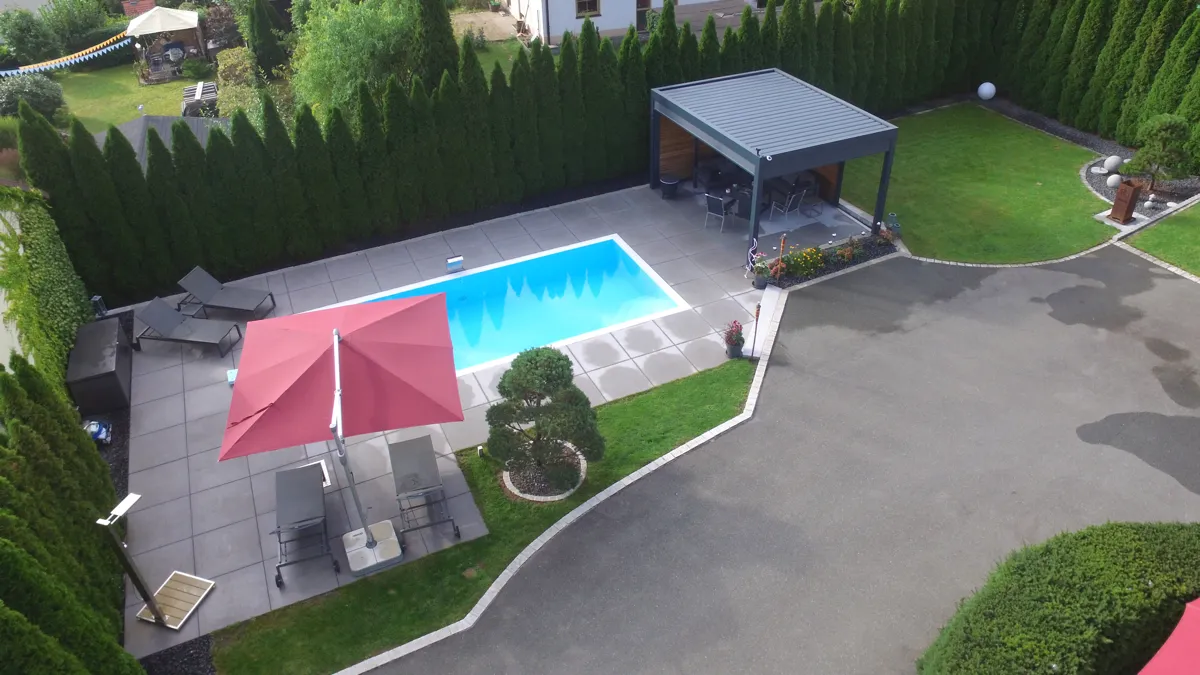 Luftaufnahme auf Poolanlage mit Liegen und Dusche